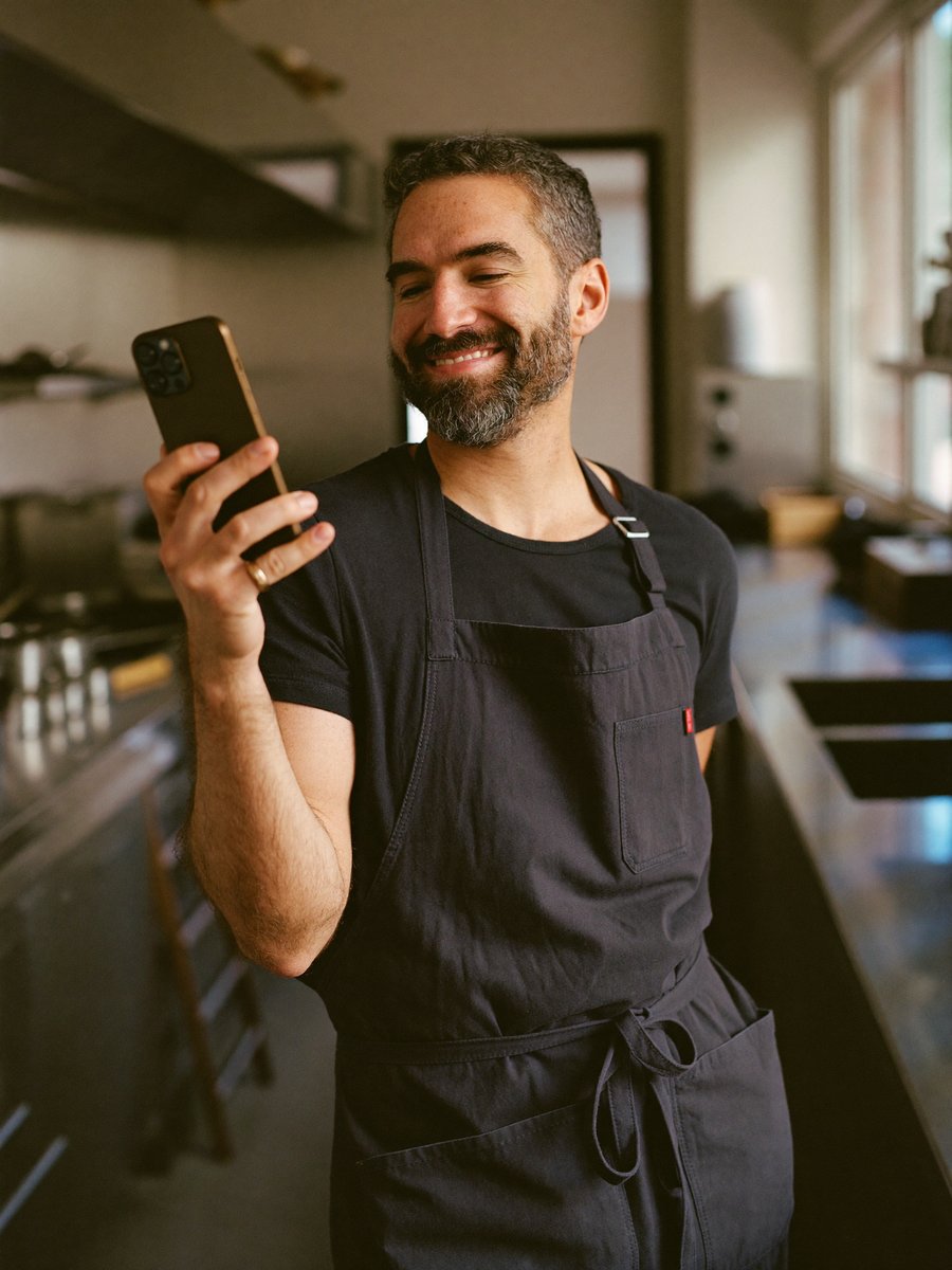 Operatore in cucina che consulta un telefono